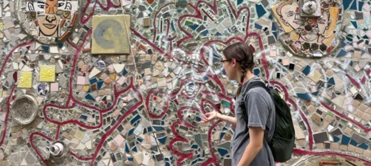 费城，一名学生站在一幅马赛克画前.